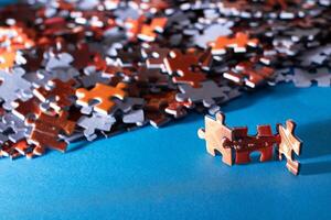 Mixed Pieces of a Colorful Jigsaw Puzzle Lie on the Blue Background - Strategy and Solving Problem Concept photo