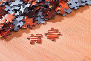 Colorful Pieces of a Mixed Jigsaw Puzzle Lie on the Wooden Table - Strategy and Solving Problem Concept photo