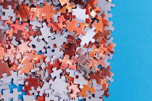 Mixed Pieces of a Colorful Jigsaw Puzzle Lie on the Blue Background - Strategy and Solving Problem Concept photo