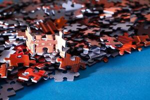 Mixed Pieces of a Colorful Jigsaw Puzzle Lie on the Blue Background - Strategy and Solving Problem Concept photo