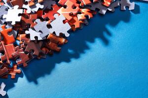 Mixed Pieces of a Colorful Jigsaw Puzzle Lie on the Blue Background With Copy Space - Strategy and Solving Problem Concept photo