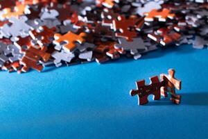 Mixed Pieces of a Colorful Jigsaw Puzzle Lie on the Blue Background - Strategy and Solving Problem Concept photo