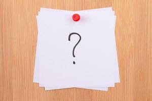 White Sticky Notes with Question Mark Pinned to the Wooden Message Board. To Do List Reminder in the Office. Memo Note at Work photo