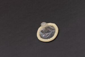 Unpacked Latex Condom On Black Background photo