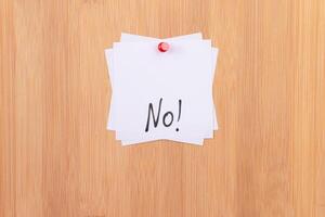 NO - White Sticky Notes with Written Word NO, Pinned to the Wooden Message Board. To Do List Reminder in the Office. Memo Note at Work photo
