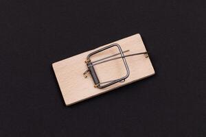 Wooden Mouse Trap. Empty Loaded Mousetrap on Black Background photo