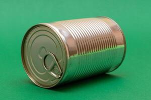 Unopened Tin Can with Blank Edge on Green Background. Canned Food. Aluminum Can for Safe and Long Term Storage of Food. Steel Sealed Food Storage Container photo