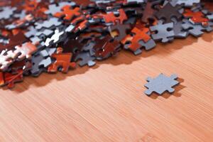 Colorful Pieces of a Mixed Jigsaw Puzzle Lie on the Wooden Table - Strategy and Solving Problem Concept photo