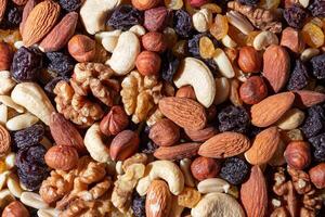 Mixed Nuts. Almonds, Walnuts, Cashews, Peanuts, Hazelnuts, Dried Prunes and Raisins. Different Nut Mix. Background from Various Nuts and Dried Fruits photo