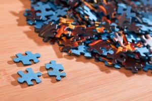 Colorful Pieces of a Mixed Jigsaw Puzzle Lie on the Wooden Table - Strategy and Solving Problem Concept photo