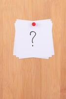 White Sticky Notes with Question Mark Pinned to the Wooden Message Board. To Do List Reminder in the Office. Memo Note at Work photo