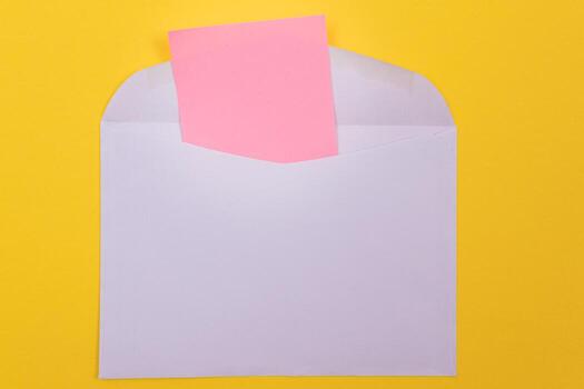 Violet Envelope with Blank Pink Sheet of Paper Inside, Lying on Yellow Background - Mock Up with Copy Space. Receiving Mail or Notice, Sending Postcard - Top View, Flat Lay photo