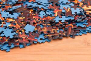 Colorful Pieces of a Mixed Jigsaw Puzzle Lie on the Wooden Table - Strategy and Solving Problem Concept photo