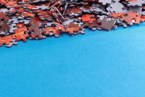 Mixed Pieces of a Colorful Jigsaw Puzzle Lie on the Blue Background With Copy Space - Strategy and Solving Problem Concept photo