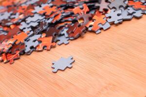 Colorful Pieces of a Mixed Jigsaw Puzzle Lie on the Wooden Table - Strategy and Solving Problem Concept photo