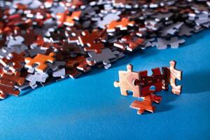 Mixed Pieces of a Colorful Jigsaw Puzzle Lie on the Blue Background - Strategy and Solving Problem Concept photo