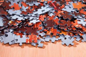 Colorful Pieces of a Mixed Jigsaw Puzzle Lie on the Wooden Table - Strategy and Solving Problem Concept photo