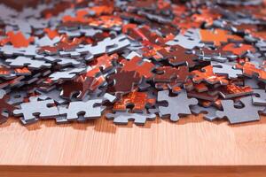 Colorful Pieces of a Mixed Jigsaw Puzzle Lie on the Wooden Table - Strategy and Solving Problem Concept photo
