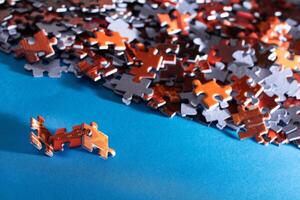 Mixed Pieces of a Colorful Jigsaw Puzzle Lie on the Blue Background - Strategy and Solving Problem Concept photo