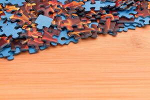 Colorful Pieces of a Mixed Jigsaw Puzzle Lie on the Wooden Table - Strategy and Solving Problem Concept photo