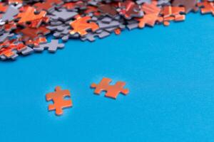 Mixed Pieces of a Colorful Jigsaw Puzzle Lie on the Blue Background - Strategy and Solving Problem Concept photo