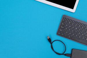 Office Workplace with Digital Gadgets Lying on Blue Table - Flat Lay photo
