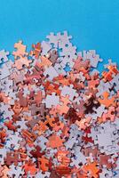 Mixed Pieces of a Colorful Jigsaw Puzzle Lie on the Blue Background - Strategy and Solving Problem Concept photo