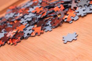 Colorful Pieces of a Mixed Jigsaw Puzzle Lie on the Wooden Table - Strategy and Solving Problem Concept photo