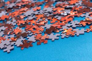 Mixed Pieces of a Colorful Jigsaw Puzzle Lie on the Blue Background - Strategy and Solving Problem Concept photo