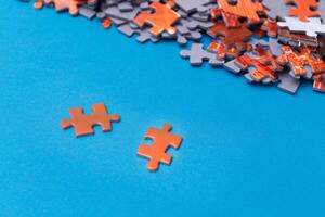 Mixed Pieces of a Colorful Jigsaw Puzzle Lie on the Blue Background - Strategy and Solving Problem Concept photo