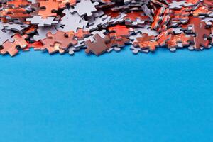 Mixed Pieces of a Colorful Jigsaw Puzzle Lie on the Blue Background With Copy Space - Strategy and Solving Problem Concept photo