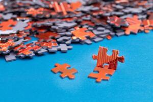 Mixed Pieces of a Colorful Jigsaw Puzzle Lie on the Blue Background - Strategy and Solving Problem Concept photo