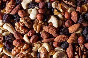 Mixed Nuts. Almonds, Walnuts, Cashews, Peanuts, Hazelnuts, Dried Prunes and Raisins. Different Nut Mix. Background from Various Nuts and Dried Fruits photo
