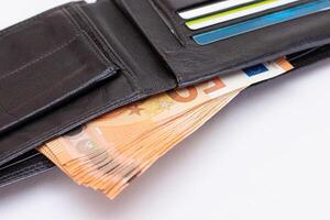 Opened Black Leather Men Wallet with Fifty Euro Banknotes and Bank Cards Inside on White Background. A Purse Full of Money and Credit Cards Symbolizing Wealth, Success and Social Status photo