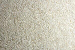 Dry Uncooked White Rice Background - Top View, Flat Lay. Scattered Raw Long Grain Rice. Asian Cuisine and Culture. Healthy Eating Ingredients. Diet Food photo