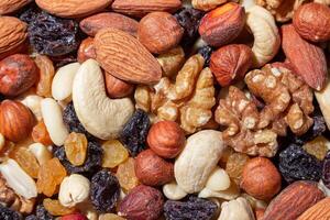 Mixed Nuts. Almonds, Walnuts, Cashews, Peanuts, Hazelnuts, Dried Prunes and Raisins. Different Nut Mix. Background from Various Nuts and Dried Fruits photo