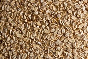 Uncooked Oat Flakes background - Top View, Flat Lay. Scattered Dry and Raw Oat Flakes. Healthy Breakfast and Diet Eating Ingredients photo