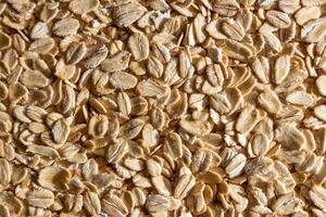 Uncooked Oat Flakes background - Top View, Flat Lay. Scattered Dry and Raw Oat Flakes. Healthy Breakfast and Diet Eating Ingredients photo