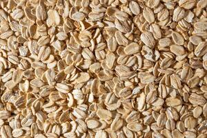Uncooked Oat Flakes background - Top View, Flat Lay. Scattered Dry and Raw Oat Flakes. Healthy Breakfast and Diet Eating Ingredients photo