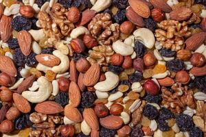 Mixed Nuts. Almonds, Walnuts, Cashews, Peanuts, Hazelnuts, Dried Prunes and Raisins. Different Nut Mix. Background from Various Nuts and Dried Fruits photo