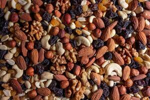 Mixed Nuts. Almonds, Walnuts, Cashews, Peanuts, Hazelnuts, Dried Prunes and Raisins. Different Nut Mix. Background from Various Nuts and Dried Fruits photo