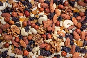 Mixed Nuts. Almonds, Walnuts, Cashews, Peanuts, Hazelnuts, Dried Prunes and Raisins. Different Nut Mix. Background from Various Nuts and Dried Fruits photo
