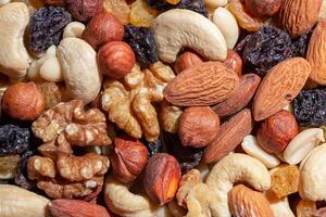 Mixed Nuts. Almonds, Walnuts, Cashews, Peanuts, Hazelnuts, Dried Prunes and Raisins. Different Nut Mix. Background from Various Nuts and Dried Fruits photo