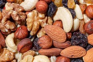 Mixed Nuts. Almonds, Walnuts, Cashews, Peanuts, Hazelnuts, Dried Prunes and Raisins. Different Nut Mix. Background from Various Nuts and Dried Fruits photo