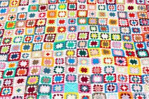 Multi colored blanket in wool, square geometric background, retro decorative pattern photo