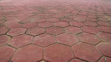 Footpath concrete block. hexagon red paving blocks. The texture of the paved tile on the bottom of the street. Cement brick squared stone floor background. Concrete paving slabs. Paving slabs. photo