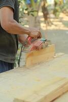 Close up of sanding a wood with orbital sander at workshop photo
