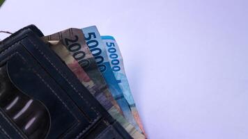 Indonesian paper money Rupiah in a wallet on a white background. photo
