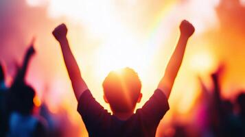 silhouette of person with raised fists against vibrant, colorful background, symbolizing celebration and triumph. scene captures moment of joy and unity among crowd photo