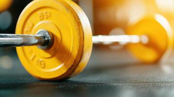 close up view of yellow weight plate on barbell, showcasing details of equipment in gym setting. vibrant color and focus highlight importance of fitness and strength training photo